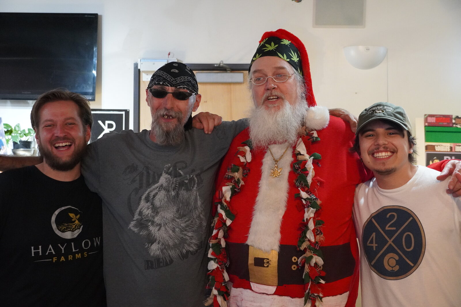 Smoking Santa with three grinning staff members at a dispensary